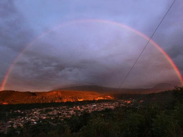 A rainbow forms over the town of Santiago Xalizintla where the Popocatepetl volcano is covered by clouds in Mexico. (AP Photo)