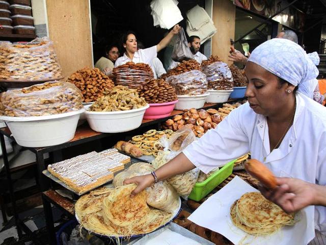 A vendor sells traditional cakes of fried honey and flour pastries to customers ahead of Ramadan in the medina of the Moroccan city of Rabat. (Reuters Photo)