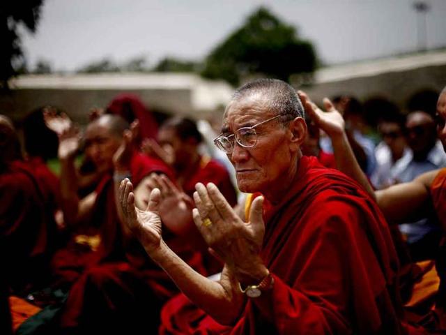 Tibetan Buddhist monks pray for peace following series of blasts in Bodh Gaya on Sunday at Rajghat, a memorial to Mahatma Gandhi.(AP Photo)