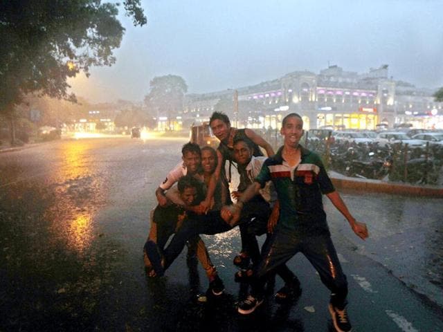 People pose enthusiastically in Connaught Place, New Delhi even when heavy rains lash the city. (HT Photo/Ajay Aggarwal)