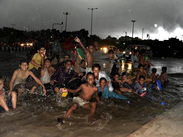 Who cares! Rain or not, we are game say these children as rains lashed the city on Tuesday evening. (HT Photo/Shubham Gupta)