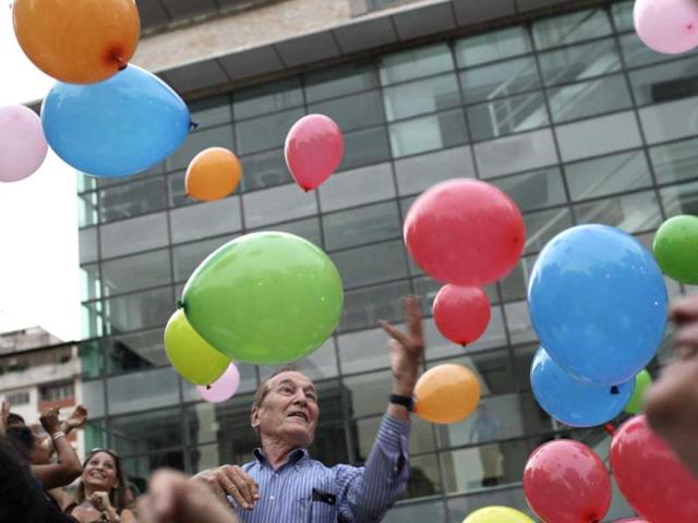 People play with balloons as they attend a laughter therapy session in a public plaza in Caracas, Venezuela. AP