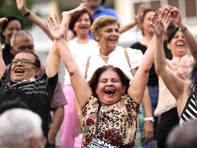 People attend a laughter therapy session in a public square in Caracas, Venezuela. AP