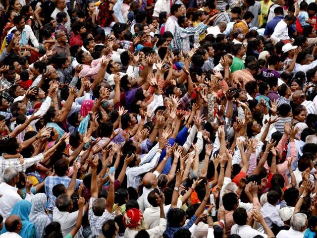 Devotees raise their hands to catch offerings during the annual chariot procession of Hindu god Lord Jagannath in Ahmadabad. AP/ Solanki