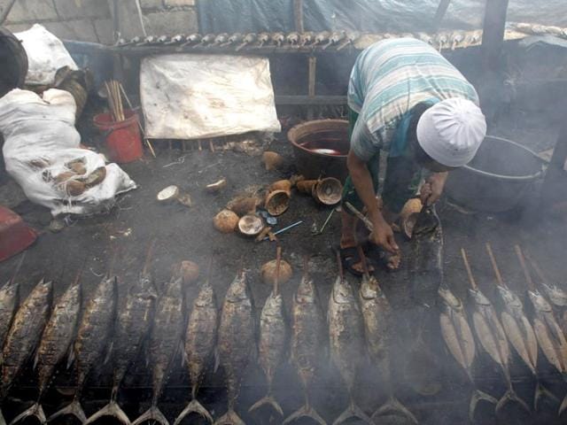 A Muslim man cooks yellow fin tuna before selling them at a market during the holy Islamic month of Ramadan in Manila July 10, 2013. REUTERS