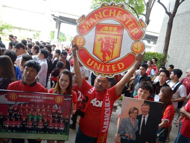 Manchester United fans hold posters as team players arrive at Don Muang International airport in Bangkok ahead of a July 13 friendly against a Thai All-Star XI as the club begins its new era under boss David Moyes. AFP