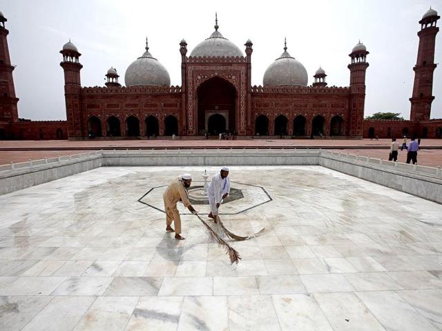 Workers clean the floor of the Badshahi Mosque ahead of the holy month of Ramadan in Lahore. Reuters