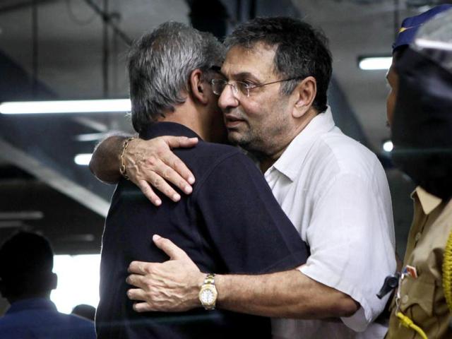Pran's son Sunil Sikand hugs a family member.