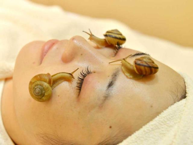 Snails crawl on the face of a woman for the demonstration of a new beauty treatment at the beauty salon "Ci:z.Labo" in Tokyo. (AFP Photo)