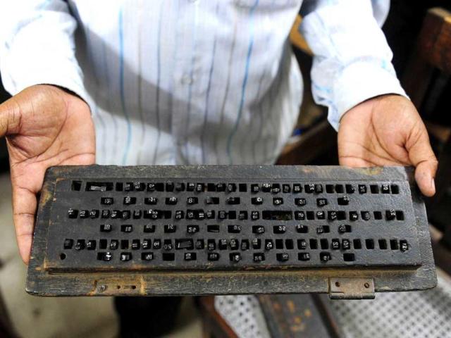 An employee holds a British period 'Date Stand' which is still in use at the Targhar Civil Lines telegraph office in Allahabad. (AFP Photo)