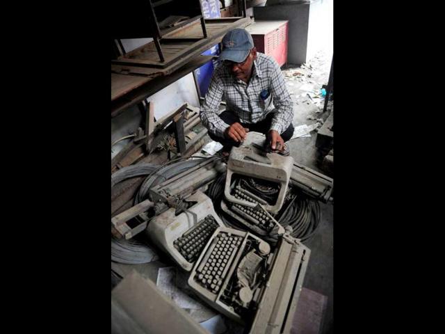 An employee looks at old typewriters laying in a store room at the Targhar telegraph office in Allahabad. (AFP Photo)