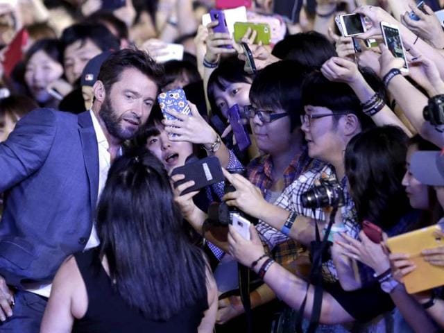 Actor Hugh Jackman takes souvenir photos with his fans during the premiere event of his new film 'The Wolverine' in Seoul, South Korea. (AP Photo)