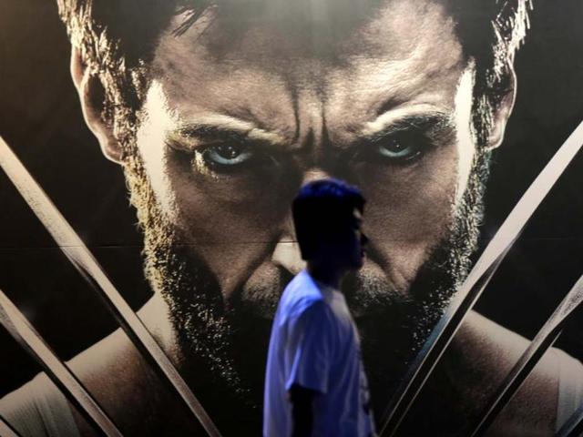 A man walks by a poster of actor Hugh Jackman during the premiere event of his new film 'The Wolverine' in Seoul, South Korea. (AP Photo)