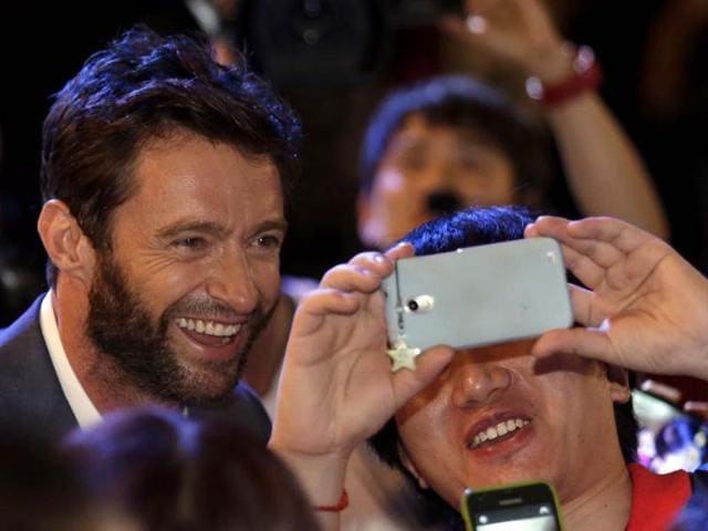 Actor Hugh Jackman takes a souvenir photo with his fan during the premiere event of his new film 'The Wolverine' in South Korea. (AP Photo)