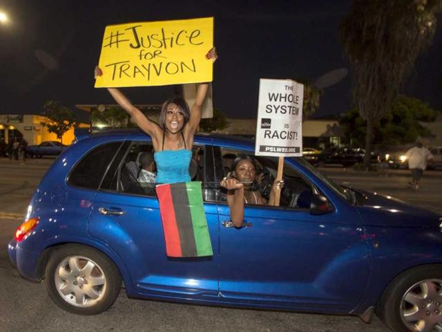 Demonstrators protest in a car on Crenshaw Boulevard during a protest in Los Angeles, the day after George Zimmerman was found not guilty in the shooting death of Trayvon Martin. (AP Photo)