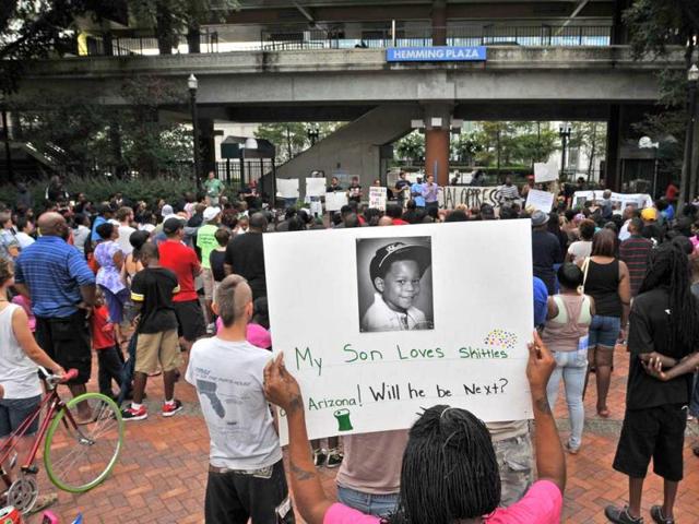 A protester holds a poster with a photograph of her son during a rally to protest against the acquittal of George Zimmerman in the shooting of 17-year-old Trayvon Martin in Florida. (AP Photo)