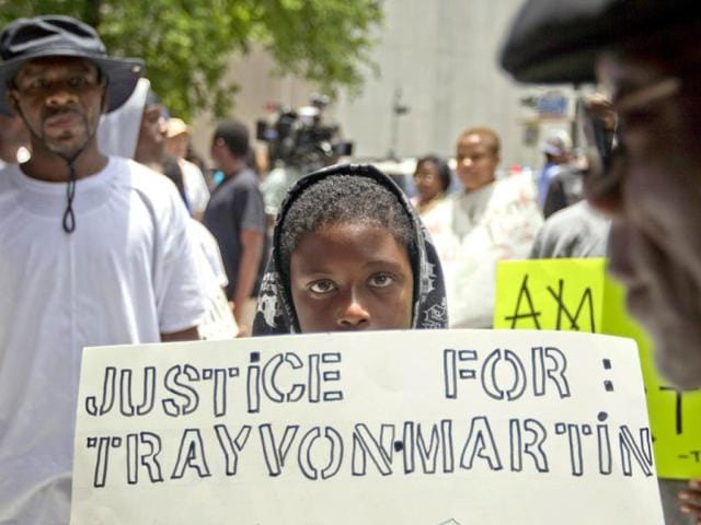 Jerald Eggleston, 10, holds a sign as he joined the more than 100 protestors organized outside the Bob Casey Federal Courthouse in Houston in reaction to the acquittal of neighborhood watch member George Zimmerman. (AP Photo)