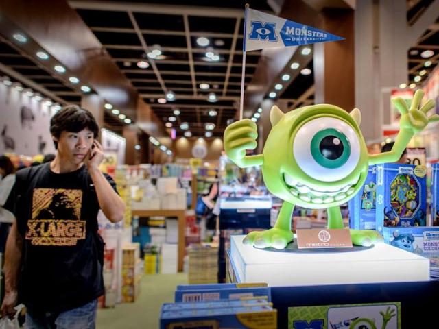 A man walks past an animated movie character figure (R) displayed at the Hong Kong Book Fair. Photo: AFP / Philippe Lopez