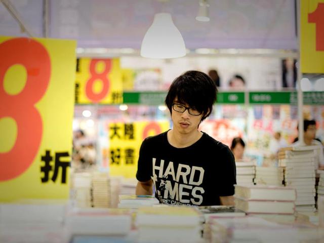 A man looks at books displayed at the Hong Kong Book Fair. The fair opened as tens of thousands of book lovers expected to flock to the seven-day annual event. Photo: AFP / Philippe Lopez