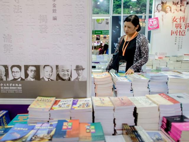 A woman browses books displayed at the Hong Kong Book Fair on July 17, 2013. Photo: AFP / Philippe Lopez
