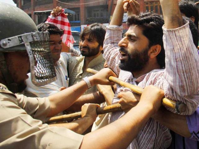 Policemen stop supporters of Jammu Kashmir Liberation Front (JKLF) during a protest against the killing of locals by Border Security Force soldiers in Srinagar. (HT Photo/Waseem Andrabi)