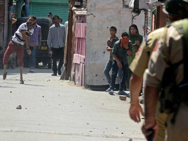 Kashmiri protesters throw stones at police during a clash against the killing of villagers by Border Security Force soldiers in Srinagar. (AFP Photo)