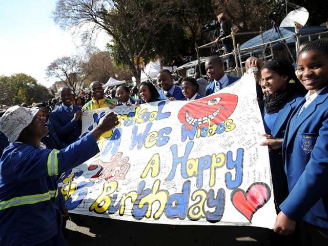 School children hold a banner with messages for the birthday of former South African president Nelson Mandela holding a banner on outside the Medi Clinic Heart Hospital in Pretoria. AFP photo