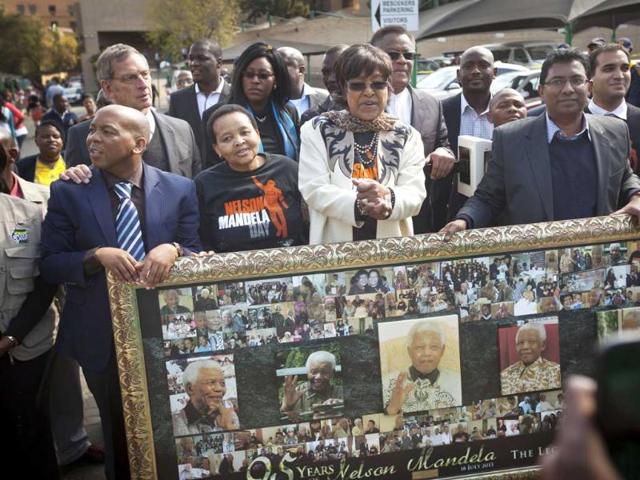 Nelson Mandela's ex-wife Winnie Madikizela-Mandela stand by a montage of photos of the former South African president inside the gate of the Mediclinic Heart Hospital where he is is being treated in Pretoria, South Africa. AP Photo