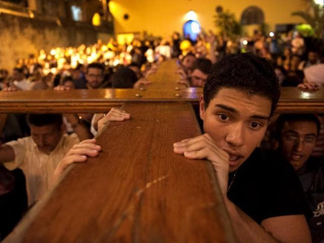 Catholics carry the world youth day cross, also known as the Pilgrim Cross, during a visit to the Rocinha slum, in Rio de Janeiro, Brazil.(AP Photo)