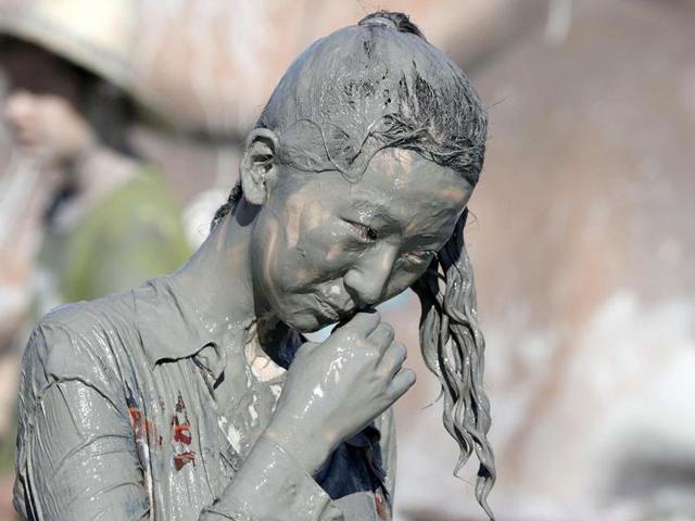 A woman walks after playing in the mud during the Boryeong Mud Festival at Daecheon beach in Boryeong, about 190 km southwest of Seoul. Reuters