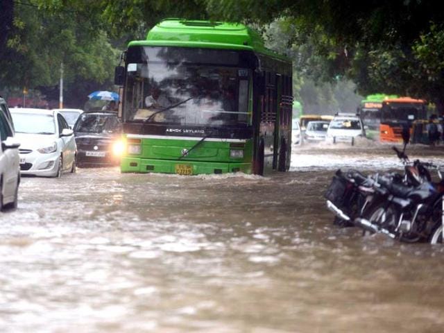 A bus tries to cross a water logged street during a heavy downpour in New Delhi. (AFP Photo)