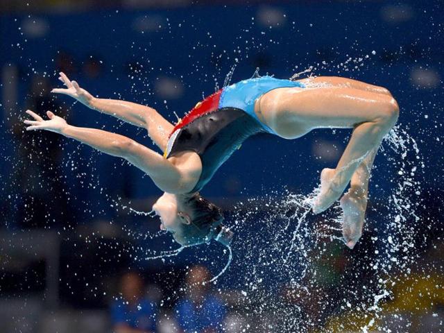 A swimmer from the Italian team is airborne as they perform their routine in the synchronised swimming free combined event at the FINA Swimming World Championships in Barcelona, Spain.(AP Photo)