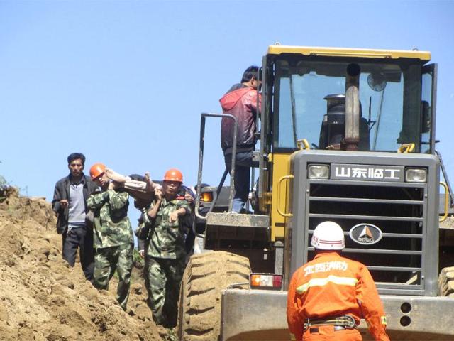 A victim is carried out on a stretcher next to an excavator after a 6.6 magnitude earthquake hit Minxian county, Dingxi, Gansu province. REUTERS