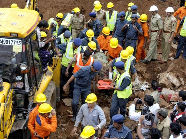 Indian National Disaster Response Force personnel retrieve a body from under the rubble of a collapsed wall at Moulali on the outskirts of Hyderabad. AFP