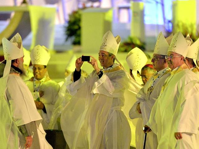 A member of the clergy takes a picture near a newly constructed altar on Copacabana beach, where pilgrims gathered for the World Youth Day inaugural Mass in Rio de Janeiro. AP