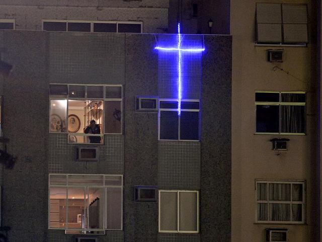 A cross is illuminated on a building near Copacabana beach where pilgrims gathered for the World Youth Day inaugural Mass in Rio de Janeiro. AP Photo