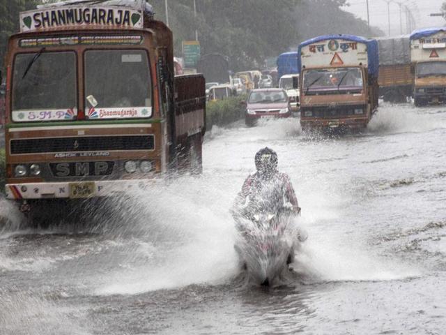 Vehicles move through a flooded road after heavy rains in Mumbai. (PTI Photo)