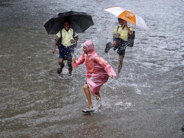 School children play on a flooded street during heavy monsoon rains in Mumbai. (Reuters Photo)
