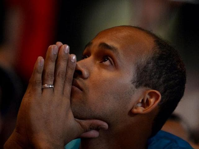 A Catholic faithful prays during the World Youth Day (WYD) opening mass, at Copacabana beach in Rio de Janeiro, Brazil, on July 23, 2013. The highlight of the landmark visit of Pope Francis to the world's most populous mainly Catholic country will be WYD, a five-day event that kicks off today. AFP PHOTO