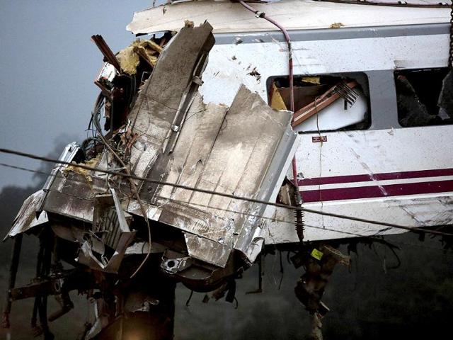 A crane removes a carriage from the tracks at the site of a train crash near Santiago de Compostela, northwestern Spain. REUTERS