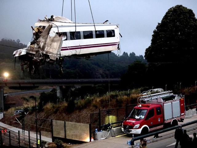 A crane removes a carriage from the tracks at the site of a train crash near Santiago de Compostela, northwestern Spain. REUTERS