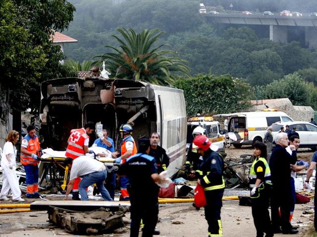 Rescuers tend to a victim next to a derailed car at the site of a train accident near the city of Santiago de Compostela. AFP PHOTO