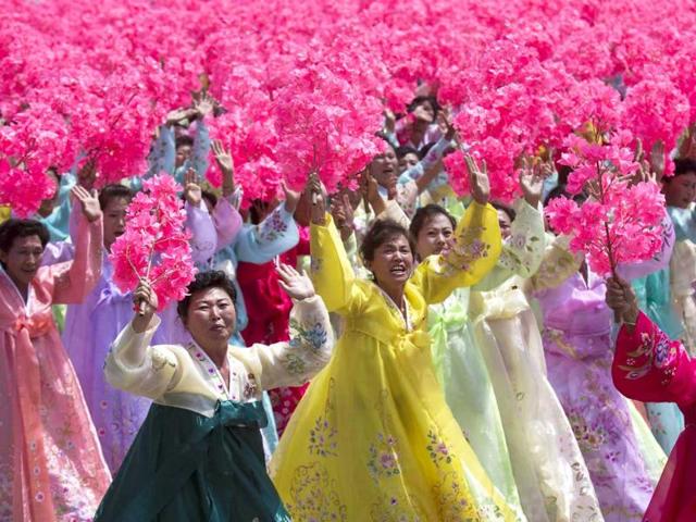 North Korean women wave to their leader Kim Jong Un during a mass military parade on Kim Il Sung Square in Pyongyang.(AP Photo)