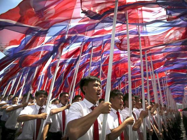 Parade participants carry the North Korean national flags during the parade marking the 60th anniversary of the Korean War in Pyongyang. (AP Photo)