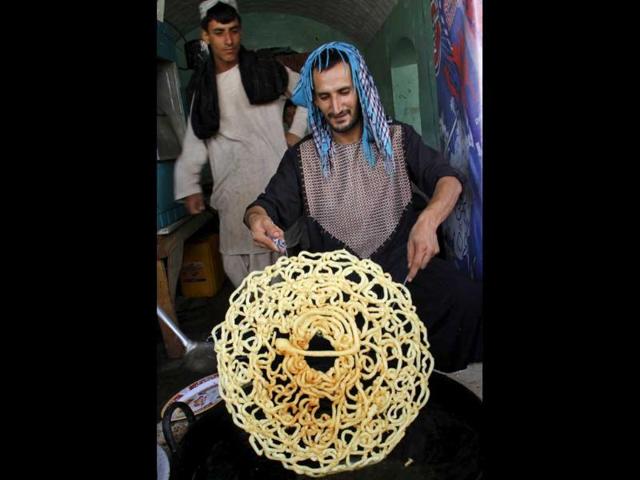 A worker makes sweets at a traditional factory ahead of the Islamic holy month of Ramzan in Kandahar, Afghanistan. (AP Photo)