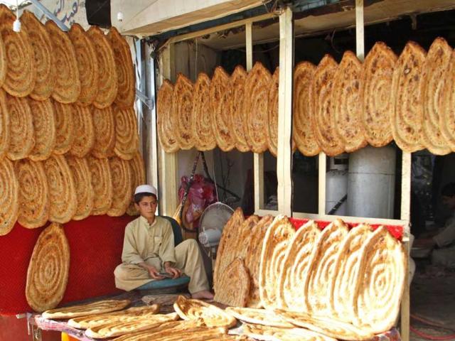 A youth selling bread waits for customers in his shop ahead of the holy month of Ramzan in Kandahar, Afghanistan. (AP photo)