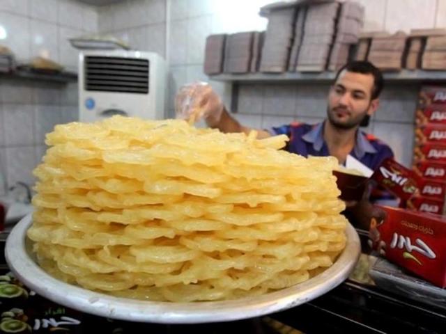 A man prepares to serve sweets at his shop during the Muslim fasting month of Ramzan in Baghdad City. (AFP photo)