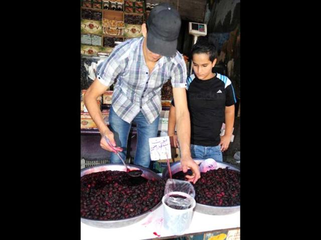 A youth sells black Mulberry outside his shop in central Damascus during the fasting month of Ramzan. (AFP photo)