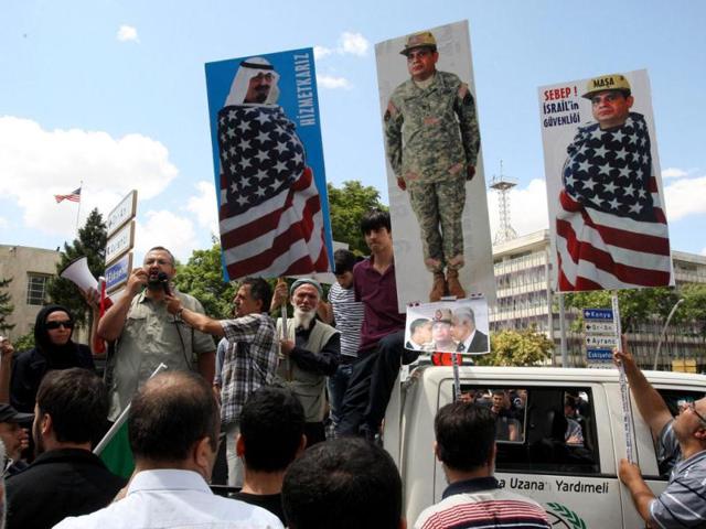 A man holds posters depicting Egypt's top general, Abdel Fattah al-Sisi, (R and 2nd R) and Saudi Arabia's King Abdullah, (L), as Turkish supporters of Egypt's ousted President Morsi demonstrate to condemn the latest killings in Egypt. (AFP Photo)