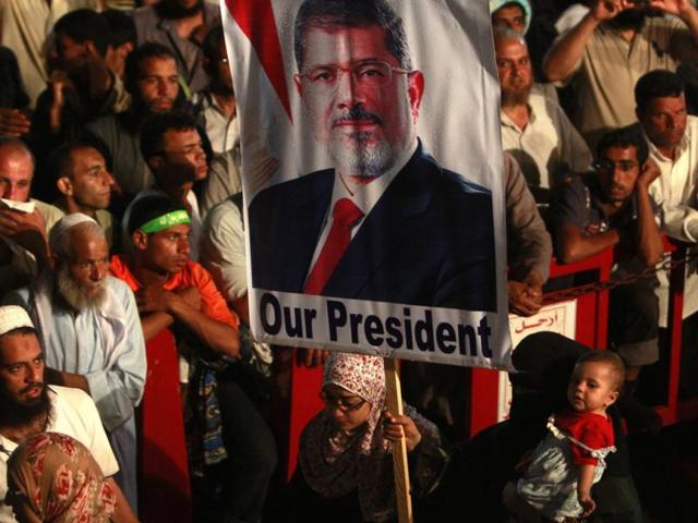 A supporter of deposed Egyptian President Mohamed Morsi holds a Morsi banner while taking part in a protest at the Rabaa Adawiya square, where Morsi supporters are camping, in Cairo. (Reuters)